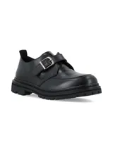 Zapatos negros de estilo masculino con textura efecto cocodrilo en la parte delantera, suela chunky dentada y tira con hebilla metálica lateral.
