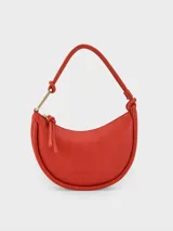 Bolso de hombro mediano color rojo, con asa corta y cierre de cremallera.