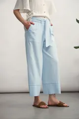 Pantalón negro de corte recto y tiro alto, con cintura elástica y lazo ajustable del mismo tejido. Presenta bolsillos laterales y un dobladillo ancho en la parte inferior.