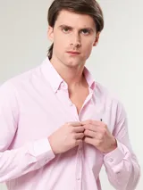 Camisa de hombre de manga larga en color rosado, confeccionada en algodón. Presenta cuello con botones (button-down) y un corte slim fit.