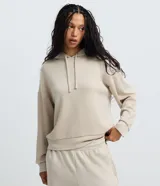 Buzo con capucha y lazo ajustable, de corte oversized y mangas largas con puños elásticos. Confeccionado en modal, viscosa, poliéster y elastano, color beige.