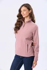 Buzo de polar color crema con cuello alto y cierre frontal parcial. Presenta detalles en cuero en el tirador del cierre y un pequeño bordado en el pecho y en la manga.