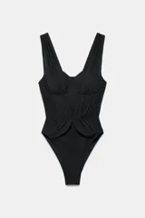 Malla enteriza negra con aros, escote corazón y tirantes anchos. Presenta detalles de tejido superpuesto estilo tul fruncido en el cuerpo.