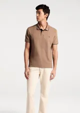 Remera polo blanca de manga corta, con cuello camisero y ribetes grises en cuello y puños. Cuenta con cierre frontal de botones y un pequeño logo bordado en el pecho.