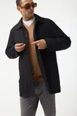 Gabardina azul marino con cuello clásico, cierre frontal con botones y bolsillos laterales.