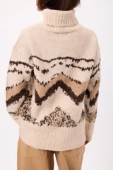 Buzo de tejido de punto con cuello alto, manga larga y diseño estampado con motivos geométricos en tonos tierra sobre fondo beige.