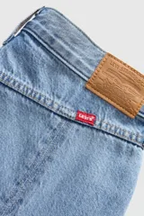 Falda midi de denim en tono azul claro, con diseño acampanado y paneles verticales tipo godet.
