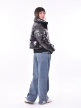 Campera puffer corta color negro brillante, con cuello alto, cierre frontal y puños ajustados.