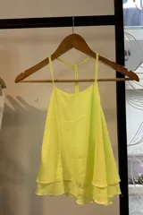 Blusa color amarillo neón con tirantes finos y corte holgado.
