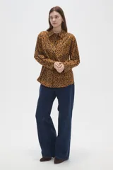 Camisa de algodón con estampado animal print en tonos marrones, de corte holgado, manga larga, cuello camisero y cierre frontal con botones.