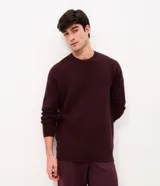 Suéter de punto para hombre color bordó, con textura acanalada horizontal, cuello redondo y mangas largas con puños ajustados.