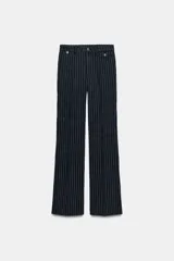 Jeans de tiro alto con corte flare y diseño de rayas verticales. Presenta cintura con trabillas, falsos bolsillos delanteros con solapa y botón, y cierre frontal con cremallera y botón.