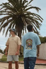 Remera unisex color beige con estampado pequeño de hongos en el frente y estampado grande en la espalda con un paisaje que incluye el sol, una montaña, un río y hongos.