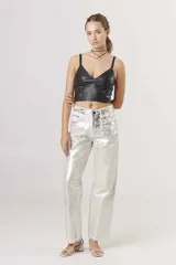 Pantalón de jean corte regular con acabado metalizado plateado, diseño de cinco bolsillos y cierre frontal con botón y cremallera.