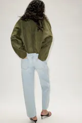 Jeans de tiro alto con diseño de cinco bolsillos, corte slim y bajo con acabado sin costuras. Cierre frontal con cremallera y botón.