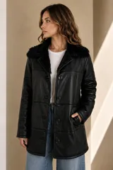 Campera babylamb de cuero color negro con interior y cuello de piel sintética negra, cierre frontal de botones y bolsillos laterales.
