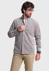 Camisa de pana gris con cuello abotonado, manga larga y corte clásico.