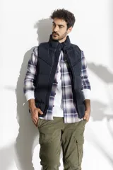 Chaleco acolchado azul marino con cierre frontal y cuello alto.