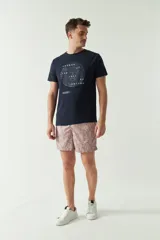 Short de baño estampado con diseño geométrico en tonos verdes, cintura elástica con cordón ajustable, bolsillos laterales y bolsillo trasero.