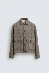 Sobrecamisa de corte boxy fit confeccionada en tejido con mezcla de lana. Presenta cuello solapa, cierre frontal con botones, mangas largas con puños abotonados y dos bolsillos delanteros tipo plastrón con solapa y botón.