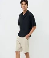 Bermuda masculina de sarga color beige, corte slim, con bolsillos y trabillas para cinturón.