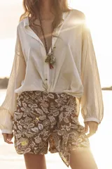 Short de tiro alto con detalle de nudo delantero y bordados florales perforados.