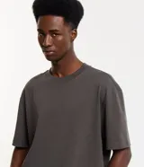 Remera de corte relaxed y mangas cortas, confeccionada en algodón de efecto pesado, con cuello redondo y diseño liso en color gris.