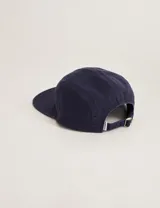 Gorra azul marino de algodón con visera recta y parche con logo en forma de rombo en el frente.