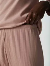 Pijama de dos piezas color rosa, compuesto por una remera de mangas largas con cuello en V y un pantalón largo de corte recto.