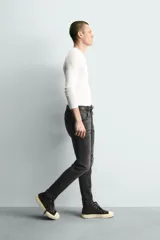 Jeans skinny fit de corte ajustado y tiro medio en color negro con efecto lavado y detalles desgastados. Confeccionados en tejido elástico con mezcla de algodón, presentan diseño clásico de cinco bolsillos y cierre frontal con cremallera y botón.