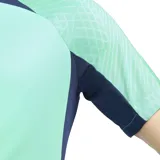 Remera deportiva Nike Dri-FIT Strike color verde agua con detalles en azul marino. Cuenta con cuello redondo, mangas cortas con diseño texturizado en los hombros y logo de Nike estampado en el pecho.