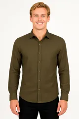 Camisa de algodón de manga larga, color verde militar, con cuello clásico y cierre frontal de botones.