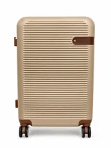 Valija rígida color champagne con diseño texturizado de líneas horizontales y detalles en cuerina marrón. Cuenta con cuatro ruedas dobles multidireccionales.