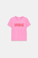 Remera de algodón color rosado con efecto lavado, de corte regular y cuello redondo, con texto rojo estampado en el frente que dice 'CENTER OF ATTENTION'.