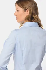 Camisa blanca de manga larga con cuello clásico y cierre frontal con botones.