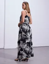 Vestido largo negro con estampado de hojas blancas, escote redondo, breteles finos regulables con detalle de cadena dorada.