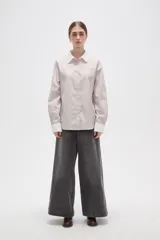 Camisa de lyocell con estampado de rayas verticales en tonos beige y blanco, corte holgado, cuello clásico y puños anchos en color blanco sólido.