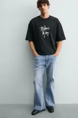Sudadera de corte relajado confeccionada en algodón, con cuello redondo, manga corta y acabado en rib. Presenta un estampado gráfico a contraste en la parte frontal.