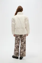 Campera puffer negra con cuello alto, cierre frontal oculto y puños tejidos acanalados. Diseño acolchado con bolsillos laterales.