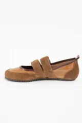 Chatita de cuero color camel, con detalles en gamuza al tono en la puntera y el talón. Presenta doble tira con cierre de velcro en el empeine y suela de goma dentada.