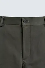 Pantalón chino de corte regular fit, confeccionado en tejido de algodón con elasticidad. Presenta bolsillos frontales, bolsillos traseros de vivo y cierre frontal con cremallera y botón.