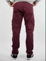 Pantalón cargo color bordó de gabardina con bolsillos laterales con solapa y detalle de etiqueta de cuero en uno de ellos.
