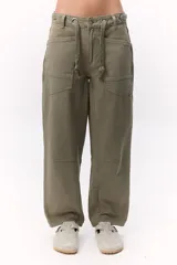 Pantalón verde militar de tiro medio con ajuste de cuerdas, pierna recta y forma levemente redondeada.