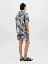 Short de baño con estampado botánico abstracto en tonos tierra, azul y gris. Cuenta con cintura elástica con cordón ajustable, bolsillos laterales y un bolsillo trasero.