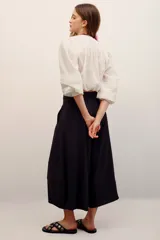 Pantalón babucha color negro, de corte amplio y largo midi, con cintura elástica y bolsillos laterales.