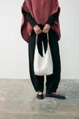 Mini tote de cuero agamuzado color blanco con acabado craquelado, diseño minimalista con asa ancha integrada, cierre con botón magnético y bolsillo interior.