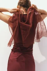 Minifalda pareo corta de encaje color marrón con diseño floral translúcido, borde inferior festoneado y tiras finas para anudar en un lateral.