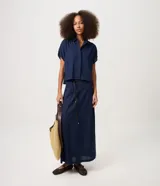 Pollera midi de corte recto, confeccionada en mezcla de viscosa y lino, en color azul marino. Cuenta con cintura con pasacintos, calce estructurado y un cinturón fino de material sintético con lazo delantero.