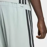 Short deportivo Adidas color verde claro, con las icónicas tres tiras laterales en negro y logo de la marca estampado en la pierna. Cuenta con cintura elástica y bolsillos laterales.