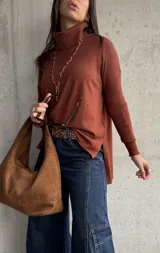 Polera de tejido de punto color chocolate, con cuello alto, mangas largas y diseño con tajos laterales en el ruedo.